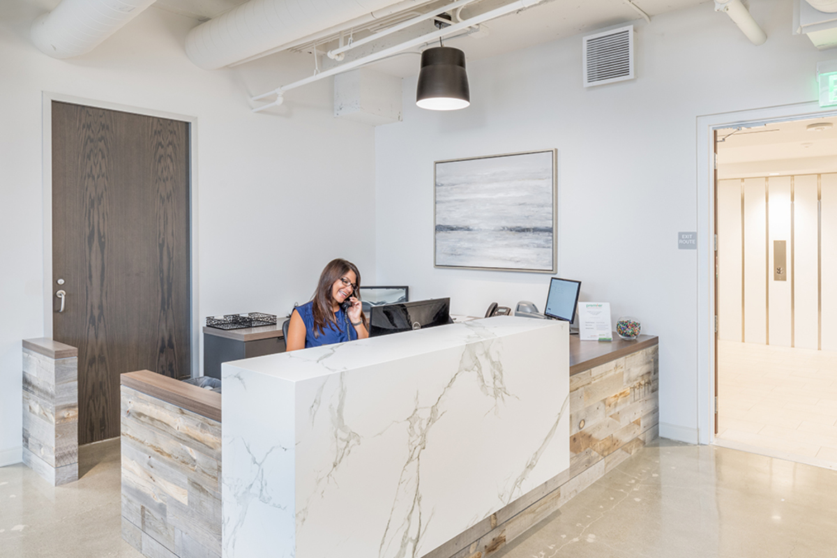 Receptionist sitting at her desk talking on the phone.